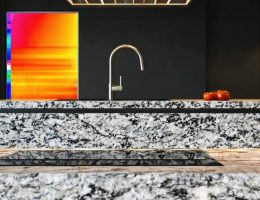 A modern kitchen highlighting granite countertops with thermal imaging overlay, showcasing granite's ability to conduct heat efficiently.
