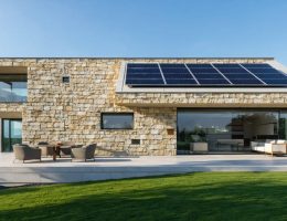 A modern stone building with integrated solar panels, demonstrating the fusion of traditional architecture with renewable energy.
