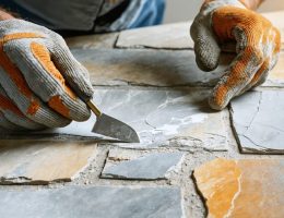 Skilled craftsman performing cultured stone repair, showcasing tools and techniques for restoring stone surfaces with precision.