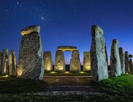 A twilight scene of ancient megalithic stone monuments showcasing precise geometric patterns and astronomical alignments under a moonlit sky.