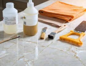 A quartz countertop showing minor chips and scratches, accompanied by tools for repair such as epoxy resin, sandpaper, and microfiber cloth, illustrating the precision and professional approach in quartz surface restoration.
