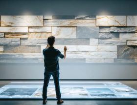 Designer utilizing augmented reality to project and visualize various stone textures on a wall, showcasing the advanced features of AR in architectural design.