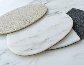 Close-up of a polished quartz countertop with an array of diamond polishing pads ranging from coarse to fine grits, illustrating the transformation process from rough to mirror-like finish.