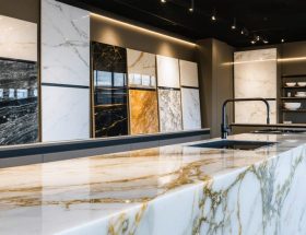A modern kitchen showcasing a luxurious quartz countertop with a waterfall edge, surrounded by an array of quartz samples illustrating different colors and stone patterns.