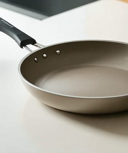 "A ceramic-coated frying pan placed on a modern kitchen countertop, showing its sleek design and smooth surface."