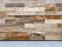 "Facade of a modern building with natural stone panels under soft daylight, set against a blurred urban skyline in the background for a sustainable design focus."