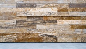 "Facade of a modern building with natural stone panels under soft daylight, set against a blurred urban skyline in the background for a sustainable design focus."