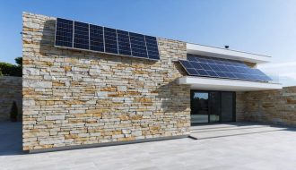 Modern building facade featuring integrated solar panels within granite stone panels, showcasing the blend of traditional architecture with renewable energy technology.