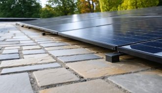 "Stone patio with solar panels integrated into the design, surrounded by garden and trees, illustrating sustainable architectural innovation."