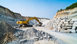 "Modern stone quarry with machinery operating in an environmentally conscious manner against a clear blue sky."