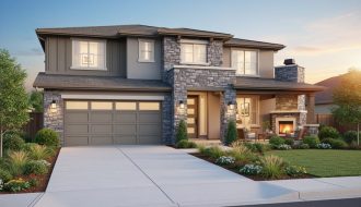 Two-story contemporary home with ledgestone accent wall framing the entry and garage, photographed at golden hour with landscaped front yard and a covered patio with stone fireplace in the background.