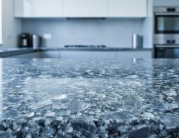 Close-up of a polished granite countertop showing detailed crystalline mineral texture in a clean kitchen setting.