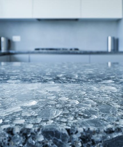 Close-up of a polished granite countertop showing detailed crystalline mineral texture in a clean kitchen setting.