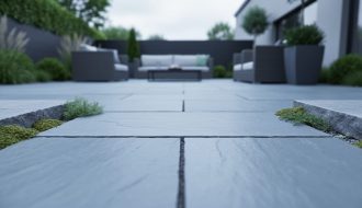 Bluestone pavers on an outdoor patio with visible stone texture and greenery between slabs, photographed in soft natural daylight.